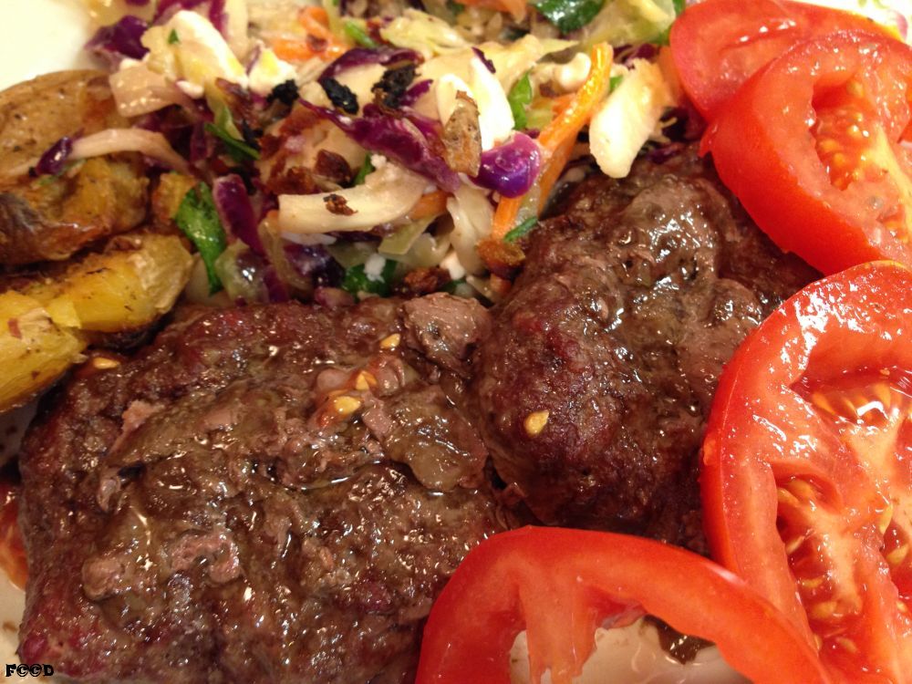 Big patty hamburgers with delightful sides of tomato and cabbage salad