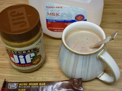 Cup of hot chocolage with milk and peanut butter to the side, looks pretty much the same as the rest, same mug, too
