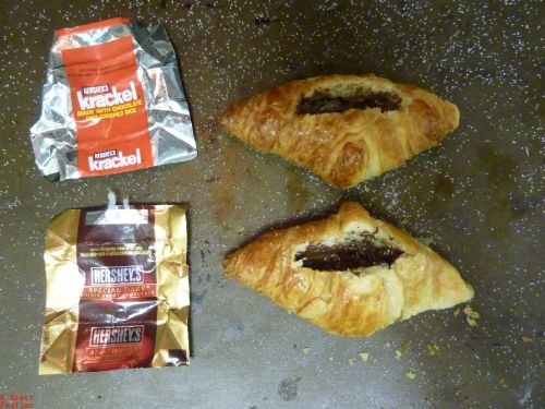 croissants with melted chocolate, wrappers next to them on the pan, chocolate and croissant is a delightful combination, right mix of sugar, salt, carbs, and all the other good stuff, like butter, fat, theobromides, and the rest
