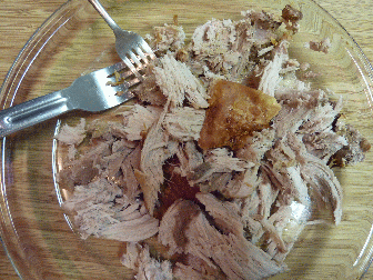 Cooking a pork butt, from raw to pulled port sandwich, pork raw, pork cooked, nice and brown, put on plate, pull apart, add pickles, oninons, vinnegar, make sandwich