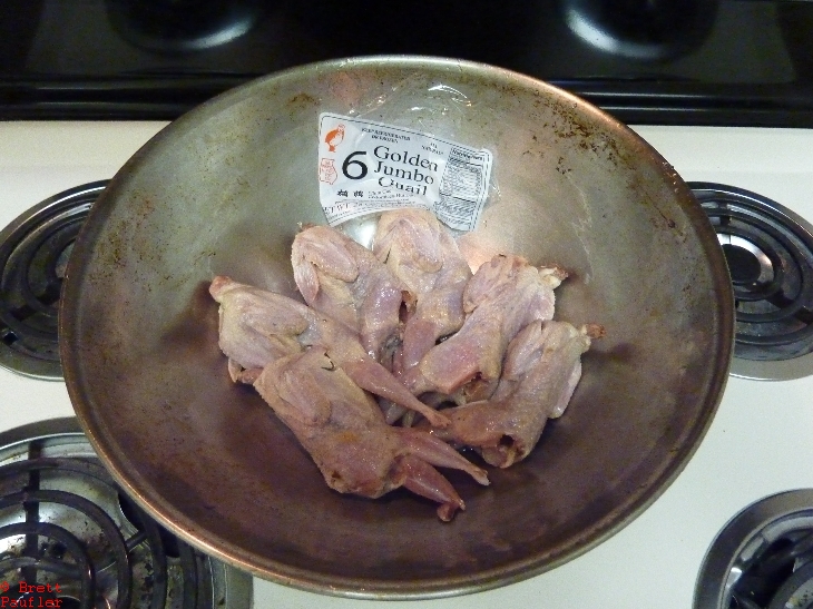bunch of raw quail ready to cook in a bowl, I guess there are six of them there judging by the label