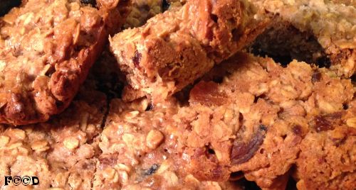 oatmeal cookie bars, a few sections flipped over and up, using apricots, walnuts, and plums in addition to the normal raisins