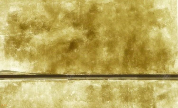 This is an image of paper covering a storefront from long ago, in the end, at this remove, it is an image of static, of differential weathering over time, a beige sort color, stretched out into a symphony