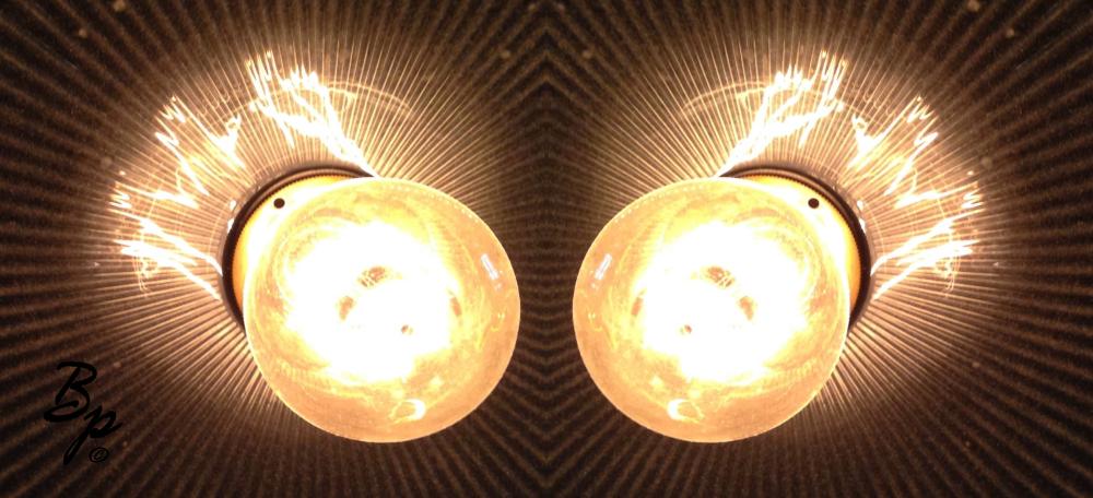 A face or dual eyes or a reverse doubled image of an old style lightbulb in outward radial lined lamp cage which sort of looks like a pair of eyes when all is said and done... or at least, that is my intent... and so, that is the filter through which I interpret it