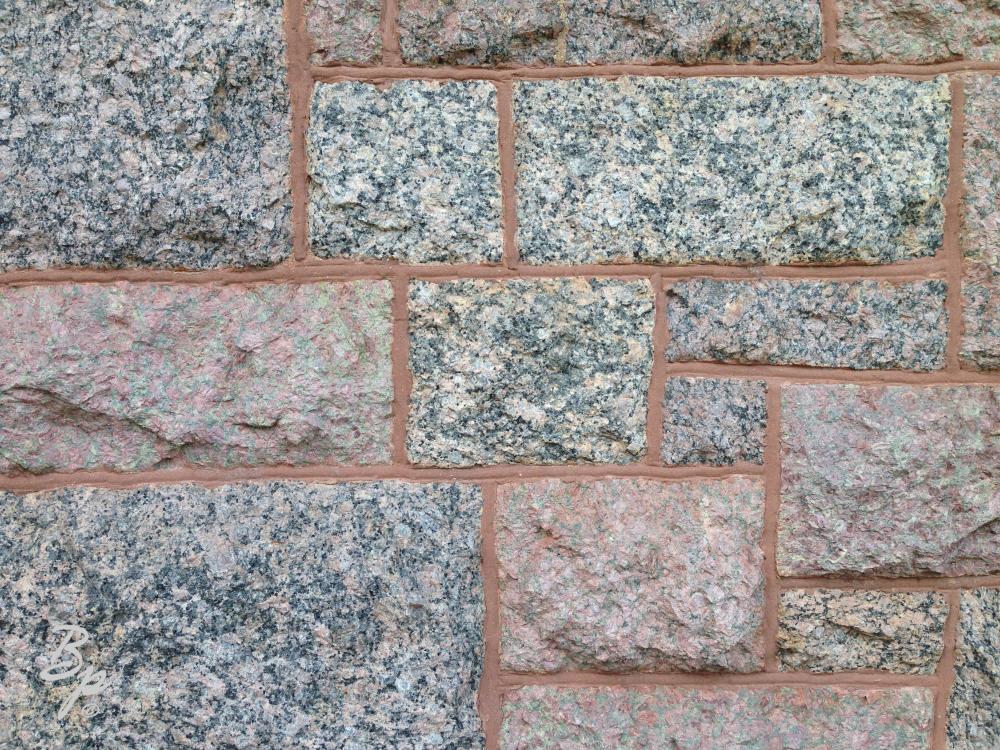 An image of stonework, masonry, granite blocks stacked together, an detail of a wall