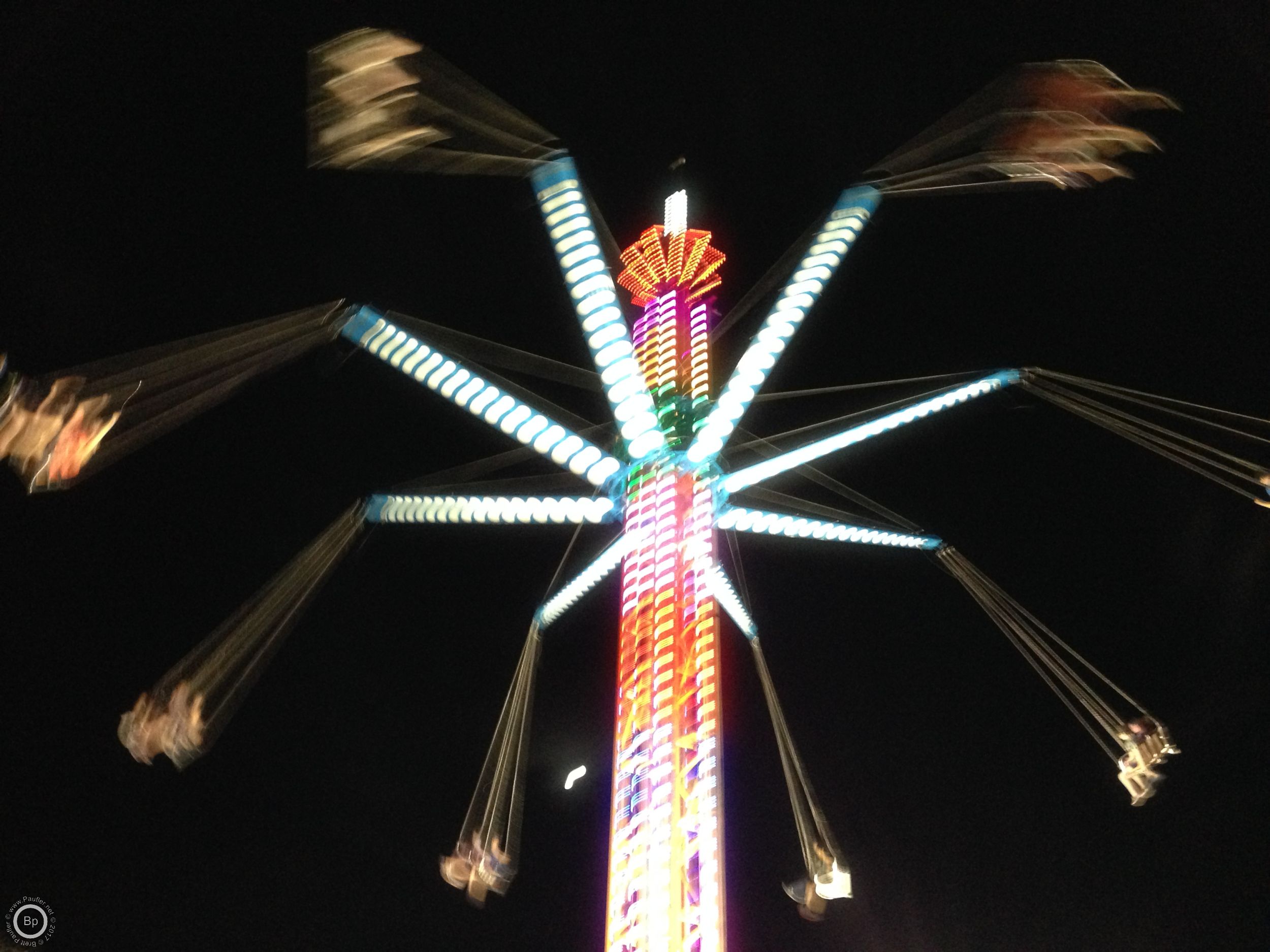 This is one of those carnival swingset rides, the ones that go around in a circle, taken to the next level, or maybe I have not been to a carnival in a while, starting at ground level, the contraption spins around, swinging the riders up, as they spindle climbs a tower, fifty feet high, probably higher, maybe two hundred, and then slowly winds back down, not getting me on one of those things, it would be an endurance ride, enduring, with little pleasure