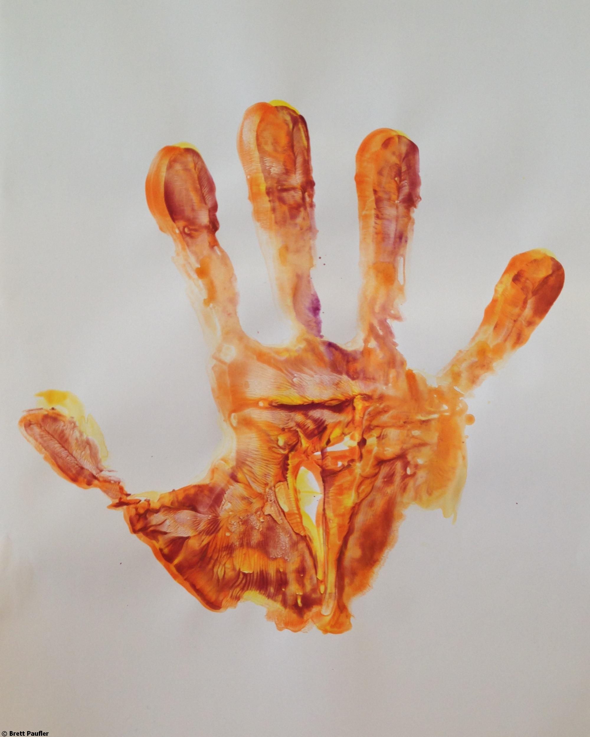 A mostly yellow hand print with slight burgandy hints