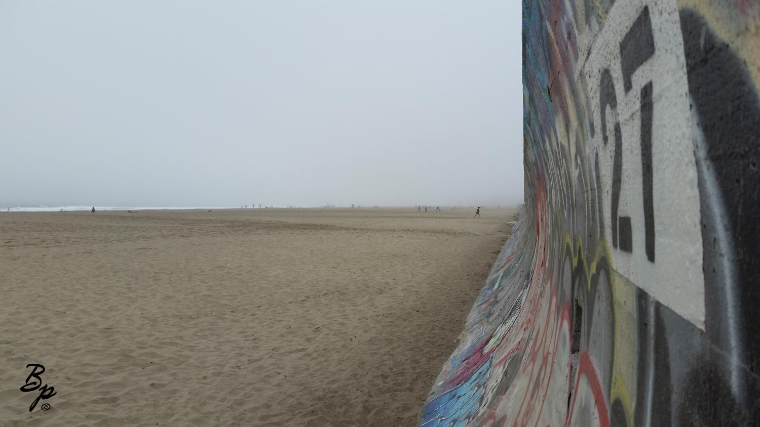 SF North Beach, I think, a long beach, full of sand, graffiti covered concrete seawall stretching to infinity on the right, number 27 prominent, a very foggy day