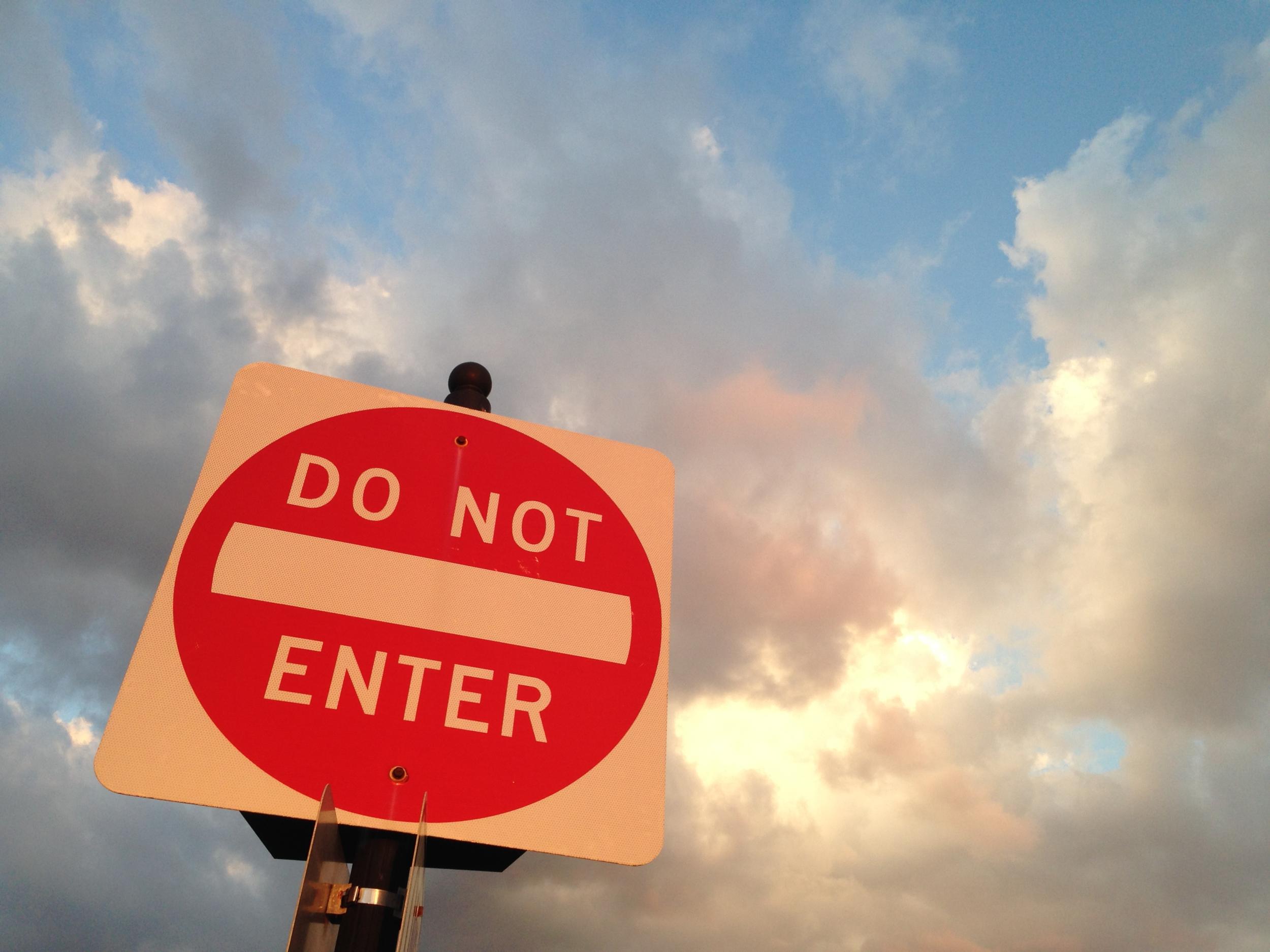 A Do Not Enter Sign with a brilliant sky in the background, clouds just pre sunset, not quite starting to turn, the Golden Hour