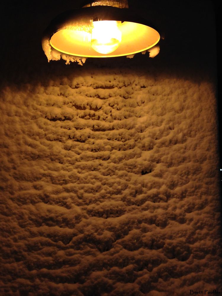 Don't! snow covered brick wall under a light