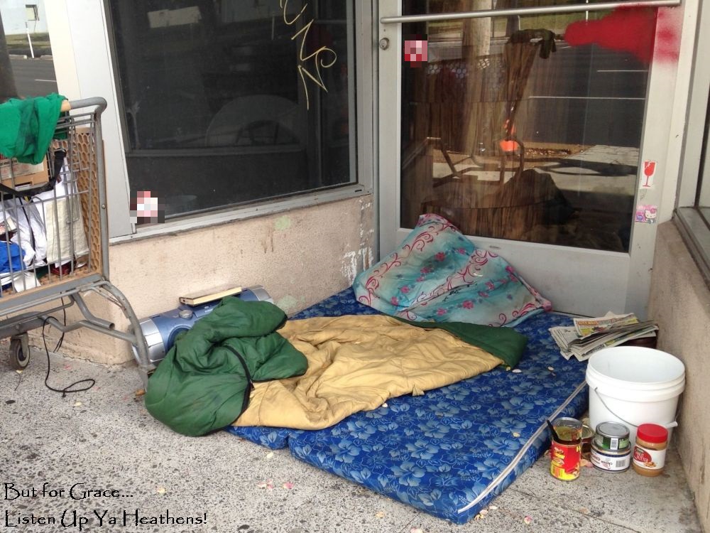 A storefront being used a crash pad, food set out, a half eaten can of chili, with overflowing shopping cart to the side