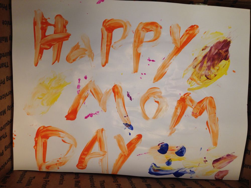 A finger painting, which reads Happy Mom Day, in glorious artful detail, complete with smiley face
