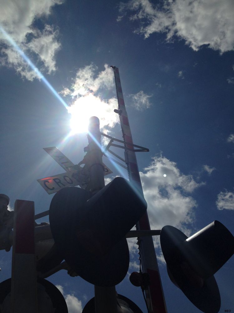 The Same Railroad Crossing, these two are, or close enough, I almost always snap images of the same one or two, this one has the sun in the background, casting a halo, setting the rest of the image in darkened shadow