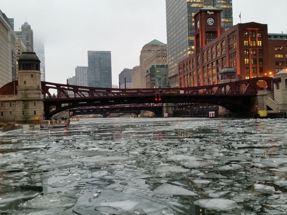 The Chicago River full of ice, well, partially full, the Encyclopedia Britania building in the background, or at least, that is what I think it is, a nice red brick structure, with a clock, and whirlpool at the top