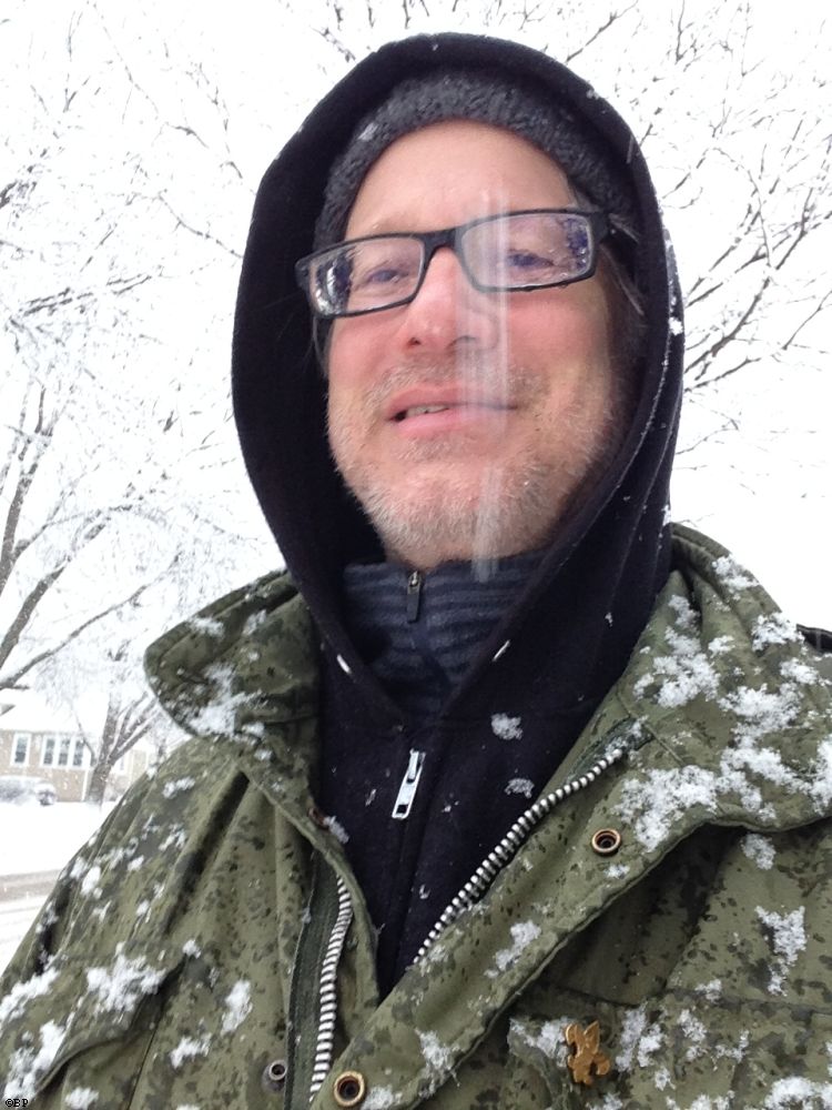 A self portrait of Brett Paufler, in the snow, that streak in front is a drab of snow coming down, eye glasses are drippig with melted snow, and the army jacket is covered in the stuff, it did not snow as much, as continually, as I would have liked or expected, but we got a few good storms, I wear a Boy Scout pin on my lapel, something I bought, and though I was a Boy Scout for some time, I have no idea if I ever earned that pin or its just an Im a Boy Scout pin, either way, I like wearing it