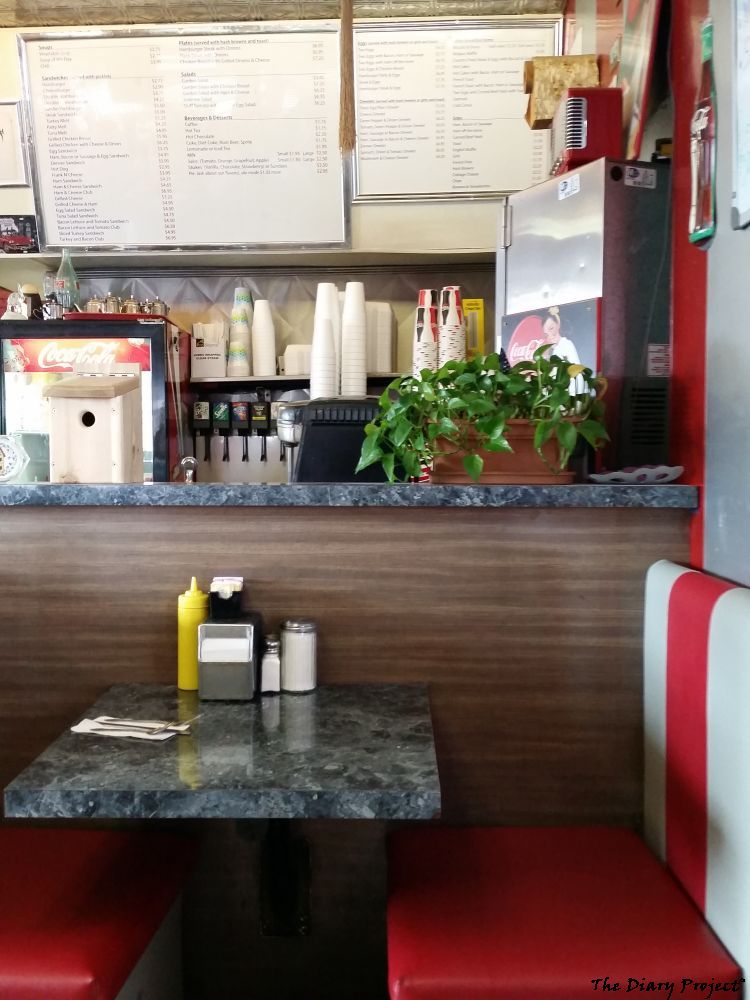 A booth in a side town diner, nice and cozy, perfect place to stop in and take the chill off, booth shown, menu board above, wonder if you can read it