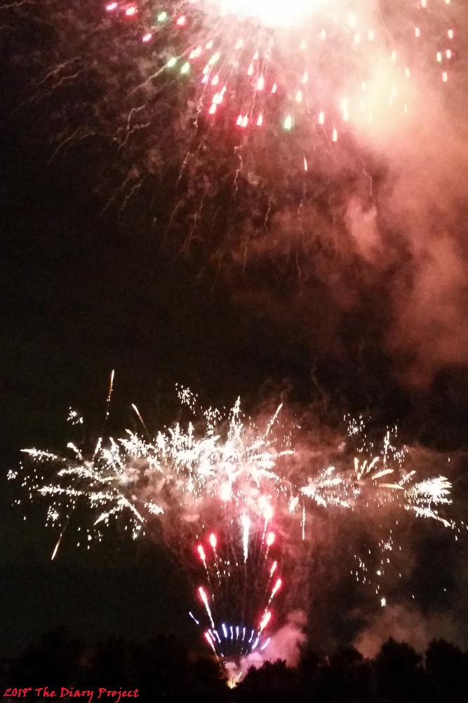 the fireworks were launched from a hill in the distance, or not so distance, on the far side of a baseball field, across the road, on a hill, the sprays were the best, awesome sprays
