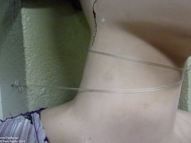 mannequin - Close Up of Ribbon Around Neck Holding to Wall