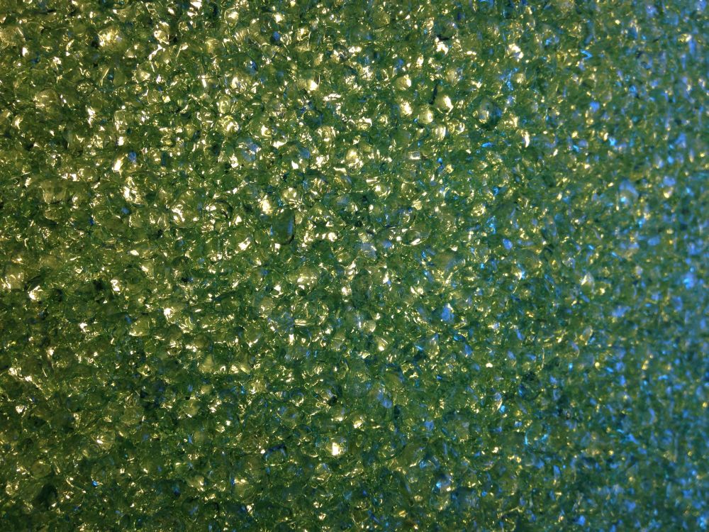 green sparkles, I like green, this is from some hanging, chandelier, type lamp shade, chandelier is probably the wrong word, cylinder of moulded plastic, small bits fused together to diffuse the light, its one of those worthless things that it is easy to assign sentimental value to, great for some college kids dorm room