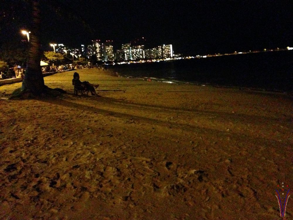 couple with lawn chair set up under palm trees, where the fireworks were in the background