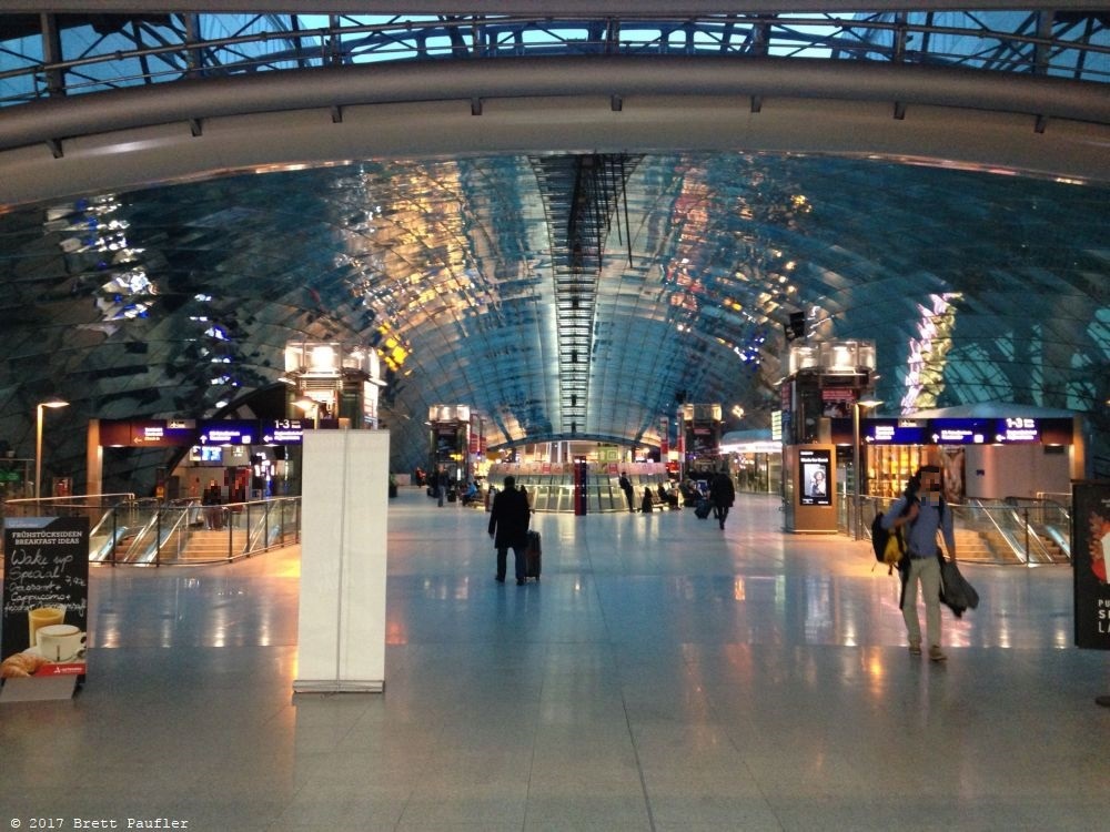 Ah, the final image, the airport, I may have to blur that face a bit, airports have some wonderful architecture, and I like the glittering lights, archway at the end of a very long concourse, they had huge fifty foot walls surrounding the airport, sight, sound, security, likely all three