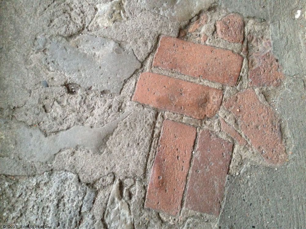 When I saw this, I was reminded of the Upvote Images for Reddit, it shows brick pavers, in a sort of arrow motif, think cobblestone, all plastered over, except for a bit which forms an arrow out of six or so bricks