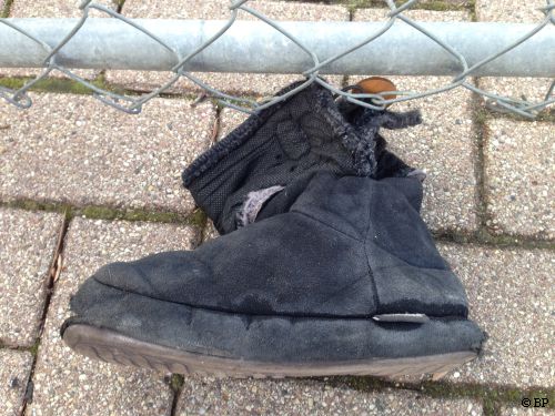 black boot, real beat up, probably from snow plow, no doubt a childs, lost when getting in the car
