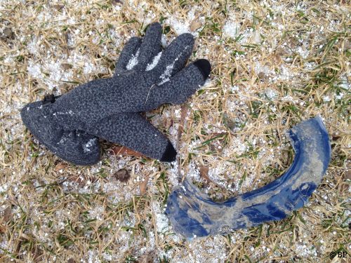 blue glove in frosted grass with some random garbage