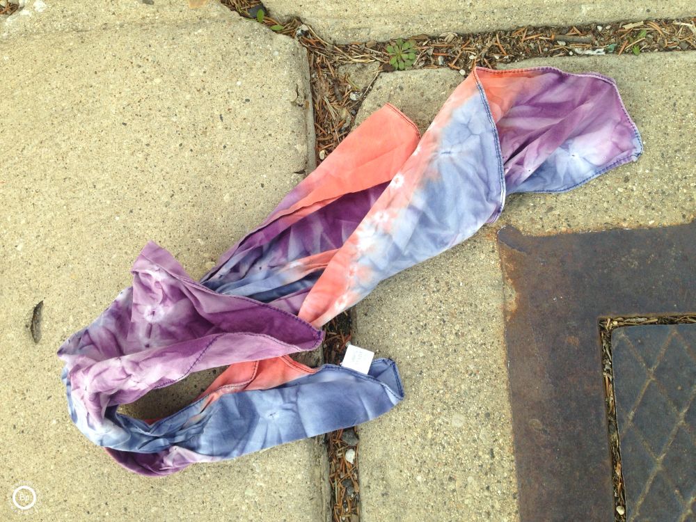 This is a tie-dye silk hankerchief, eh, not really silk, some imitation, lying on the ground in the curb, I should have grabbed this, but no bag, I have no idea what I would have done with it had I grabbed it, I have like four or five gloves and hardly ever wear them, prefering others that I have had for a while
