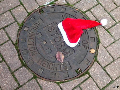 Hat lying on ground on man hole cover, including town name