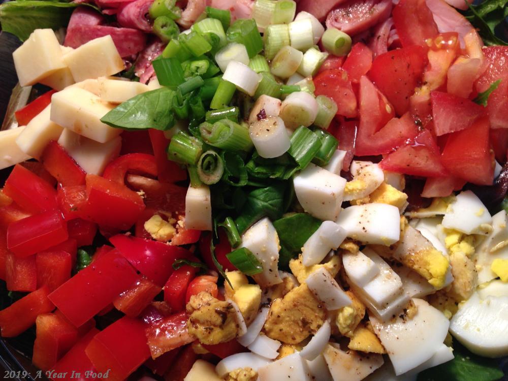 Chef Salad, salad mix, tomatoes and red peppers, green onion, egg and select deli meats rolled and sliced thin