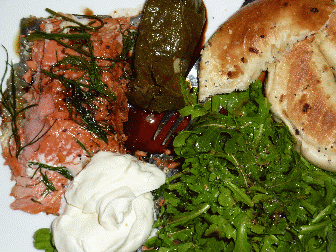 Salmon, yep, that is what it looks like, arugala salid, heavily dressed with balsamic, bagels, sour cream Im guessing and some kind of red stuff, oh, those where dalmos, damas, some kind of olive leaf wrapped rice thing, so so
