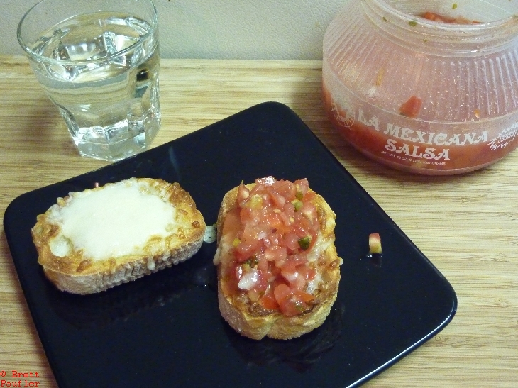 Toasted cheese toast, water, salsa in background, so salsa on top of one of the slices, without sounds better at this remove