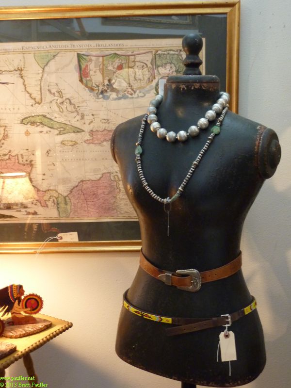 Bust, displaying jewelry, between the ambience, map in the background, primitive style jewelry and black manican, it seems very, african nativish to me, very compelling, sexually, artistically