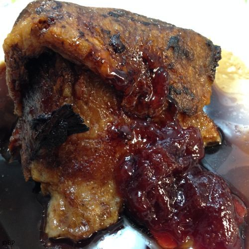 A nice triangular hunk of lamb on a white plate background, a very nice photograph, if I do say so myself, as the white edge of the image blends in with the white of the page, the lamb is served with a touch of plum jelly preserves for an extra bit of flavour