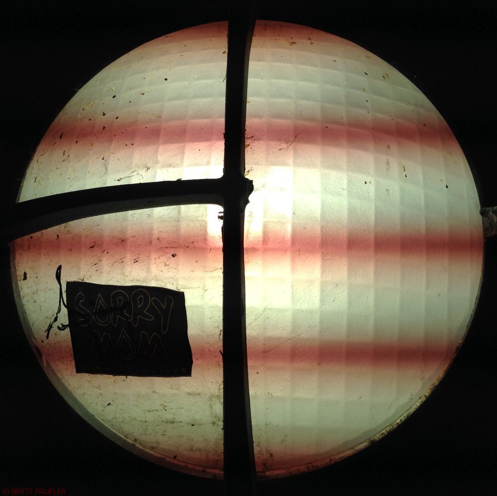 Happiness this is a light shade cover of a street tunnel light, it is split in half and then quartered on one side, with a graffiti sticker, but the cool part of it all is the wavy lines that my camera captured, interference between a flourescent bulb and the camera pick up