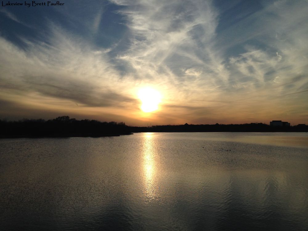 typical sunset view like a thousand others on the internet, nothing glouriously special about this one, if you are wondering why humans like sunsets, it is because of the color, the visual appeal, the soft blending of non-ordinary colors, lake in foreground, clouded sky reflecting setting sun in background, I have the desire to outright lie and say that if one looks hard enough they can find this that or the other thing in the sky or water, but for the most, it is not there