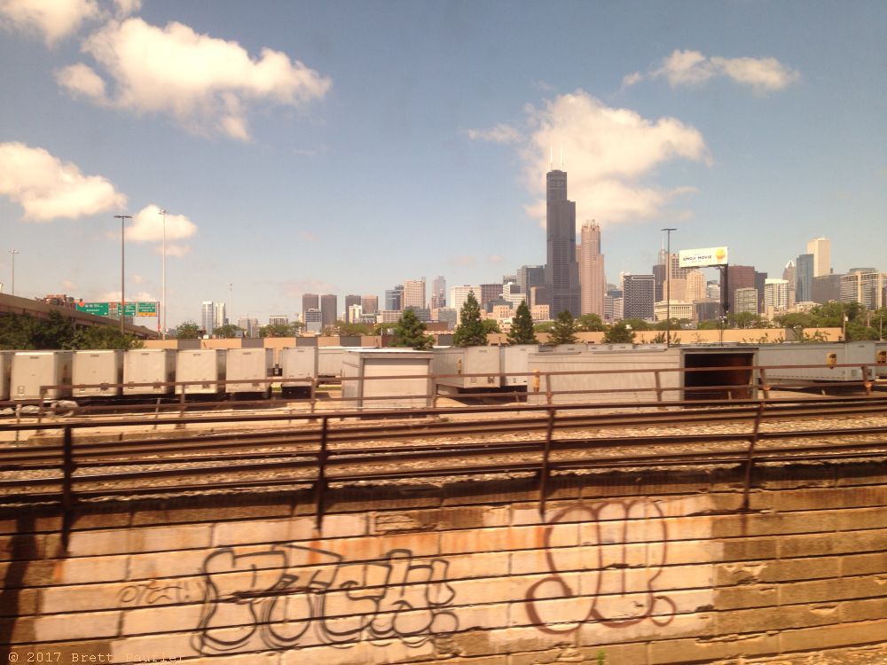 Graffiti in the foreground, the Chicago Skyline in the backgroun, I like the image, clouds are scattered across an otherwise blue sky, smooth sailing ahead