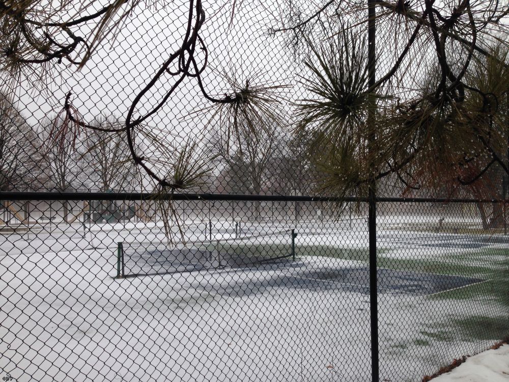 Tennis courts covered in snow, a rather forlorn view, through the fence, at the courts and playground and park beyond, a nice artsy shot, and now, the park is full... or fuller, the weather having turned nice, going to hit ninety later this week, they say