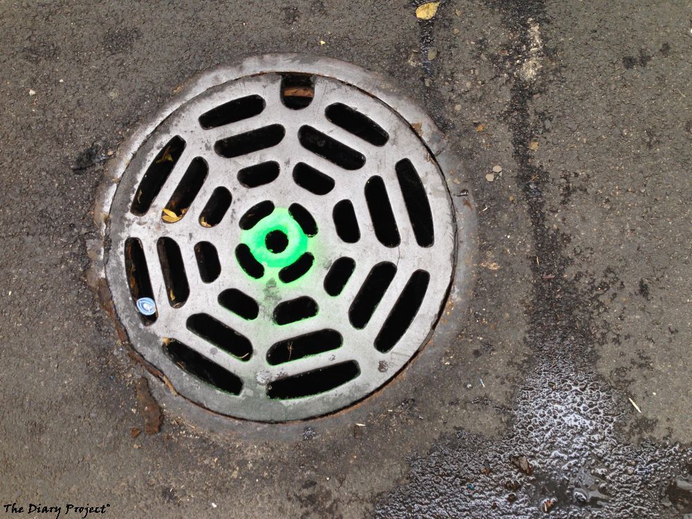 A simple mainhold cover, drain cover, with green flourescent paint sprayed into the center, causes it to glow, plays tricks with the eye, boring and weird, taking the time, it can be captivating
