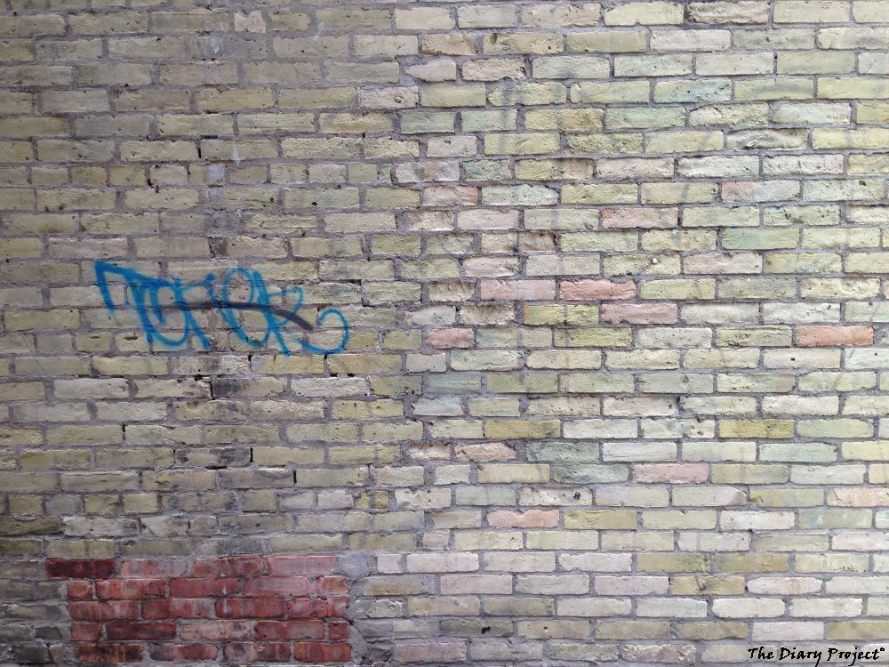 A brick wall with a bit of graffiti, nothing more, nothing less
