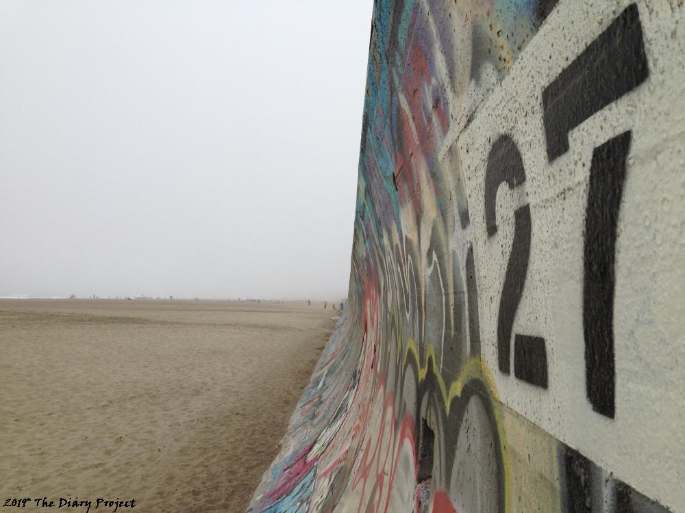 27 Sea Wall I love this shot, this is among my best, or at least, I am very pleased with it, to the right, fading into the distance is a graffiti covered sea wall, and the the left, the beach, fogged in, with a few folks, up along the ocean line, it is a pleasing shot