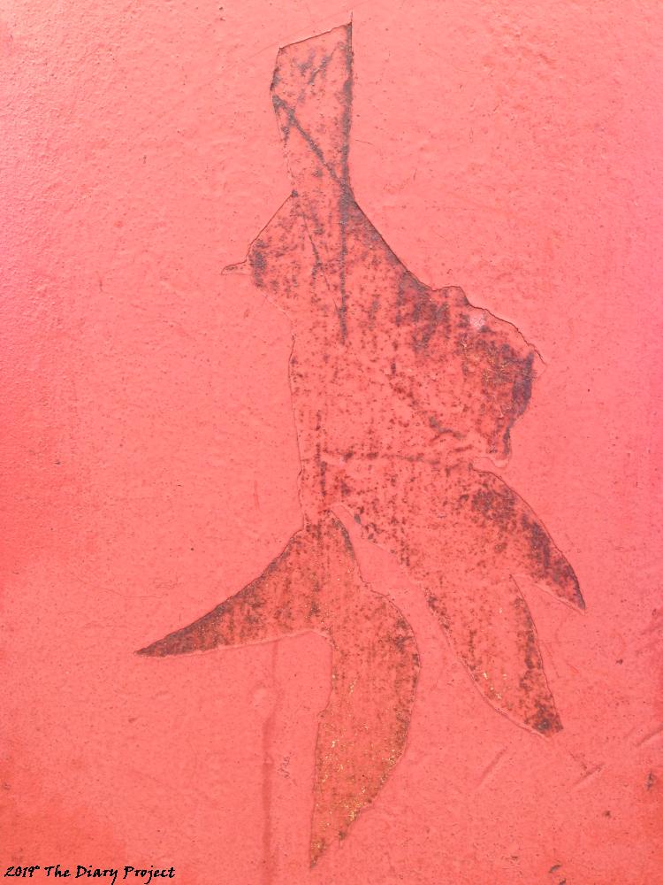 Gang Sign distressed paint on the Golden Gate Bridge, it looks like where a sticker may have been peeled off, or something more random, stray duct tape, it looks like some sort of oriental character to me, I like it
