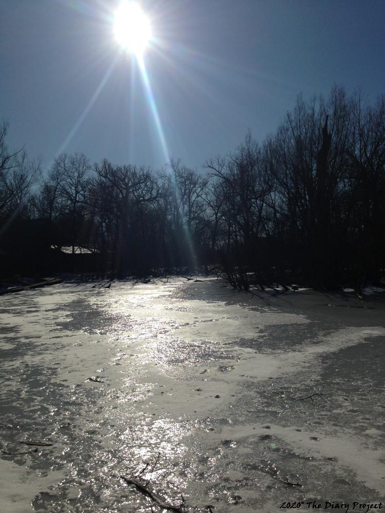 Though, this image is selected based on the text which follows, none of these pictures, as yet, correspond to the moment, this is an iced over pond, very nice, the sun reflecting off the ice, a ring of leafless trees surrounding, blue sky above, a nice day, the end of the winter, this was