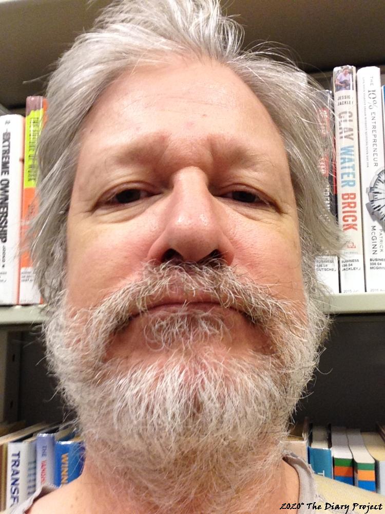 I have a beard of sorts in this picture, or at least, I am not shaving, the background is library books from the business section, random
