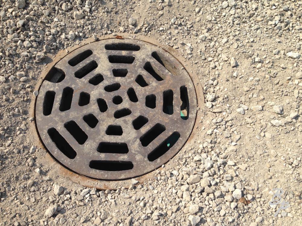 A manhole covered surrounded by gravel in the pre-paving stage, this was recently fixed in the neighborhood and I found the progression interesting, even if this is a fairly banal picture, most artsy photography is, I find it pleasing, though I do wonder if the image is worth 232kb