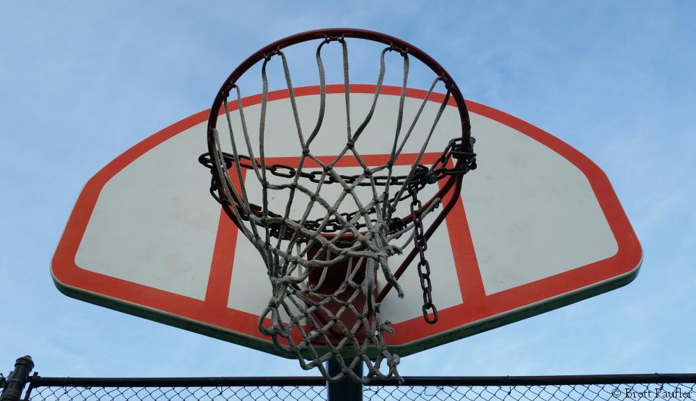 A Basketball Backboard and Hoop with a chain across the hoop to prevent play