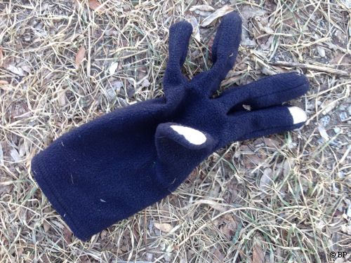 blue glove, white fingers, in grass, this is where I thought to add the ice skating pile at end