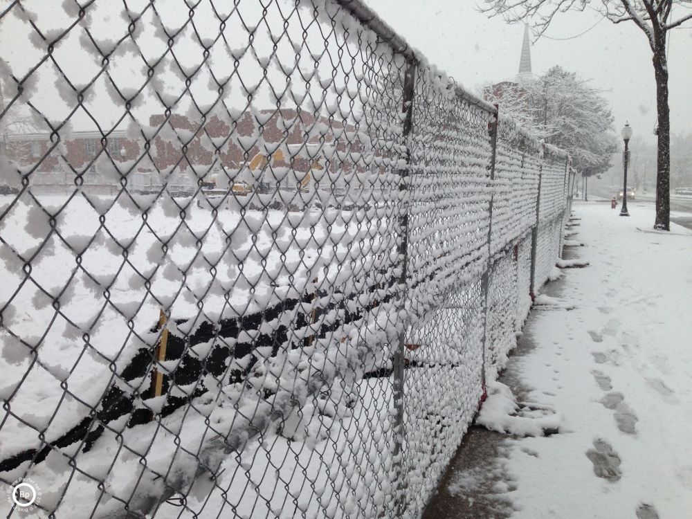 chain link fence goint off into distance, snow settling in between the wires, I like the way cyclone fences photograph, they give a nice foreground or background effect