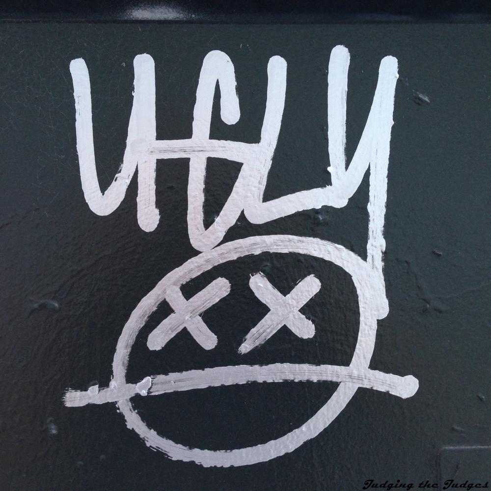 UGLY! The Start of the Graffiti, this one is for a face with the word ugly below it, it is simple, two Xs for eyes, X X, with a line underneath, I do not know that any of these images are the best fit for the text, well, the flags fit, the decision is ugly, and the two below call out to the chaotic and arbitrary nature of the law, but I do not know that they are